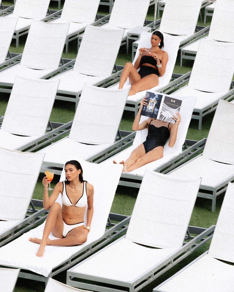 Women lounging on pool chairs_2024