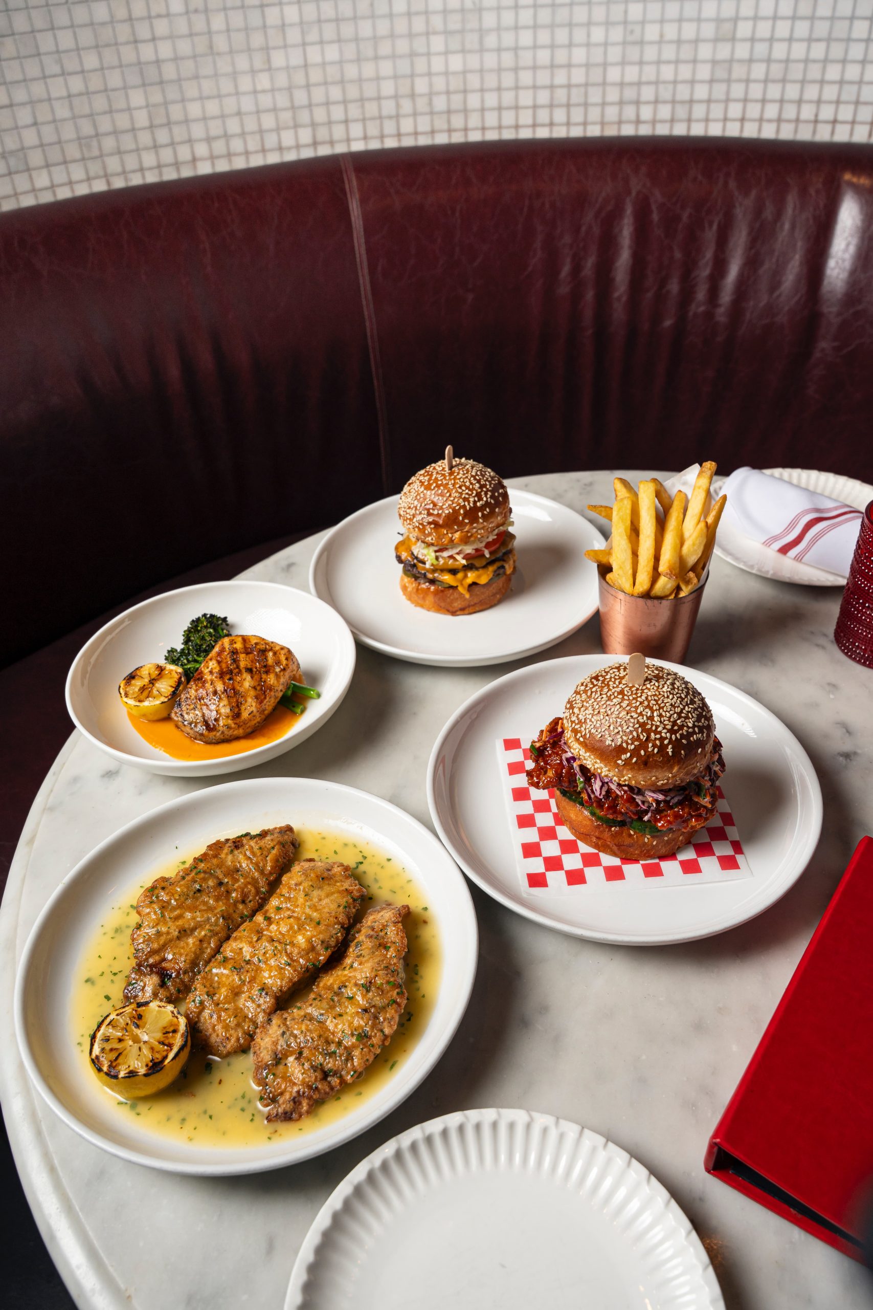 Table shot of fish, burgers, and fries at Arkadia Grill