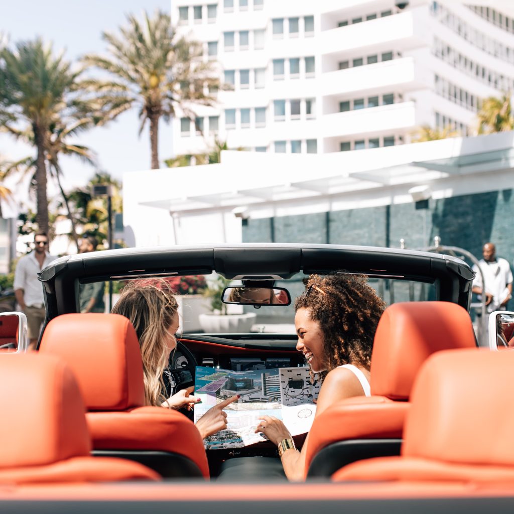 Guest in rental car holding map at Departures Drive